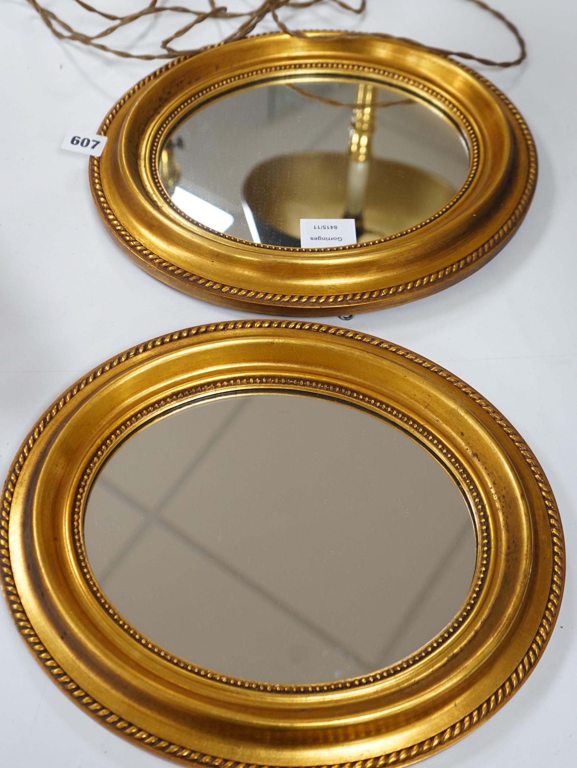 A small pair of oval gilt plaster framed wall mirrors, 34x30cm